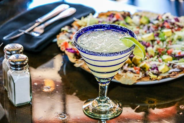 a margarita on a table with food