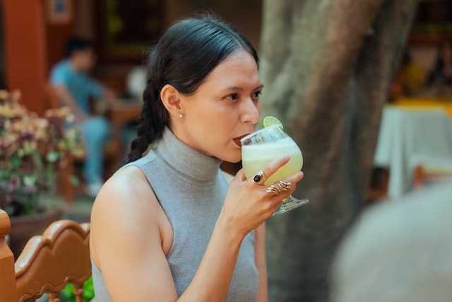 a woman drinking a margarita