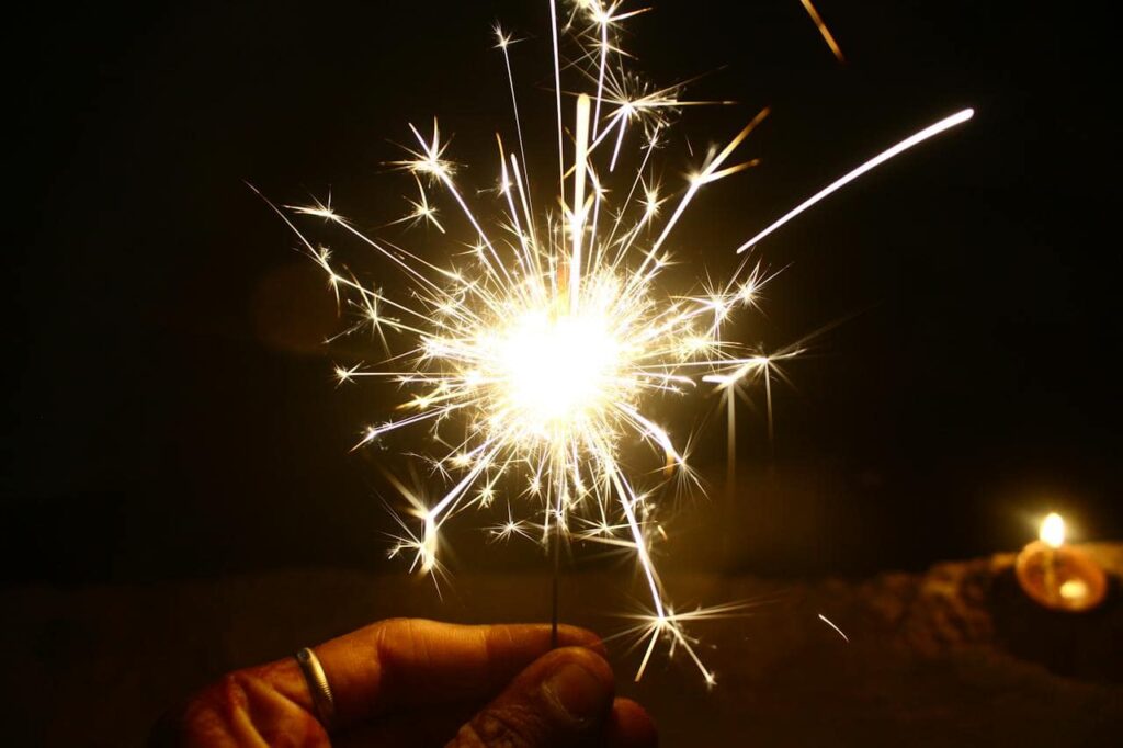 a person lighting a firework for New Year’s Eve