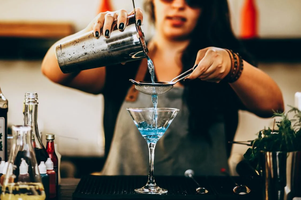 woman pouring blue liquid from drink mixer