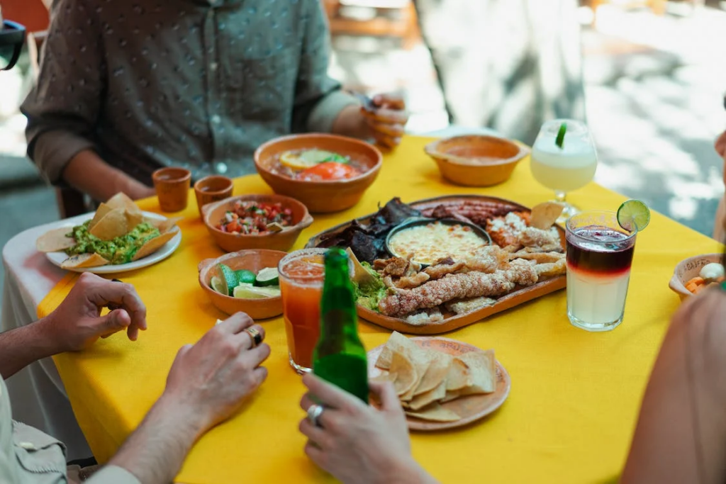 mexican foods and drinks on a yellow table