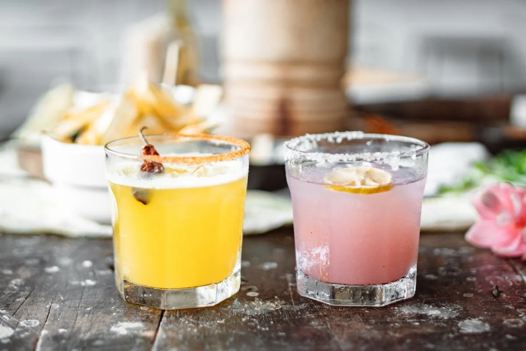 pink and yellow alcoholic beverages in clear glass