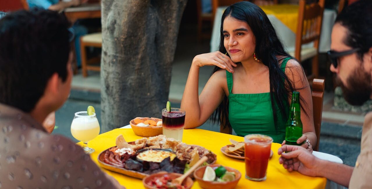 woman in green tank top sitting on chair in front of table with food